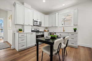 Kitchen featuring white cabinetry, hardwood / wood-style floors, stainless steel appliances, a textured ceiling, and sink