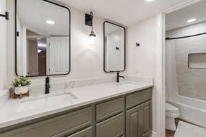 Full bathroom with toilet, shower / bath combo, and vanity