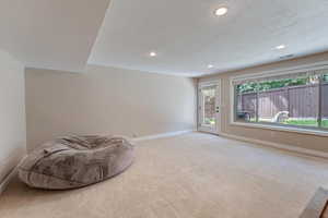 Unfurnished room featuring a textured ceiling and light colored carpet