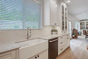 Kitchen featuring light stone counters, white cabinets, and light wood-type flooring