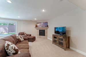 Carpeted living room featuring a fireplace and a textured ceiling