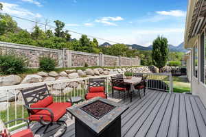 Deck with a fire pit and a mountain view