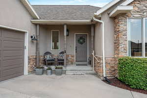 Entrance to property featuring a porch and a garage