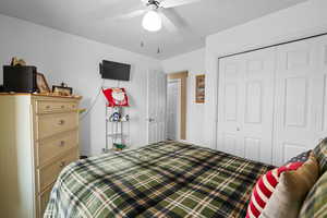 Bedroom featuring ceiling fan and a closet