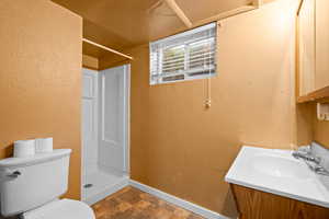 Bathroom with toilet, walk in shower, and vanity