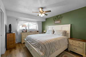 Bedroom featuring a textured ceiling, ceiling fan, and light hardwood / wood-style floors