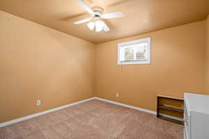 Unfurnished room featuring ceiling fan and carpet