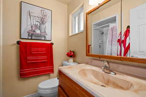 Bathroom featuring toilet, a shower with shower curtain, and vanity