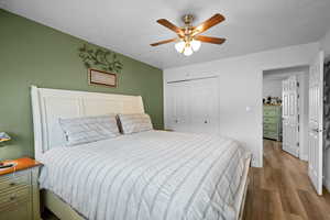 Bedroom with a closet, ceiling fan, and light hardwood / wood-style floors