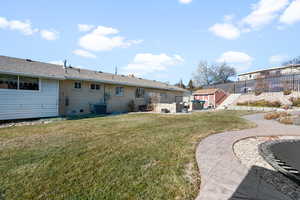 Rear view of property with a patio, an outdoor living space, central AC, and a lawn