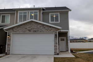 View of front of home with a garage and a mountain view