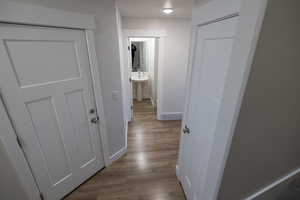 Hallway featuring a textured ceiling, light hardwood / wood-style flooring, and sink