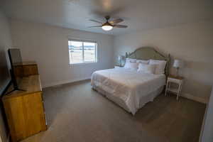 Carpeted bedroom featuring ceiling fan