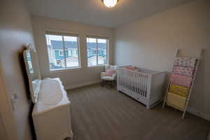 Bedroom featuring a nursery area and carpet floors