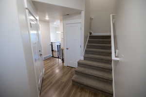 Stairway with a textured ceiling and hardwood / wood-style flooring