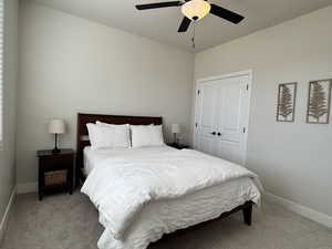 Carpeted bedroom with a closet and ceiling fan