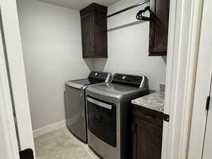 Laundry area featuring cabinets and washer and clothes dryer