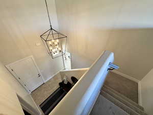 Stairs with a chandelier and carpet