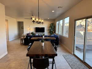 Dining room featuring ceiling fan with notable chandelier