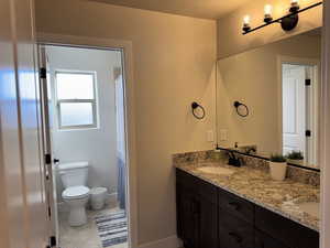 Bathroom with tile patterned flooring, vanity, and toilet