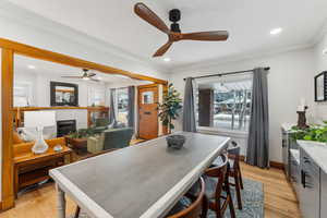 Dining room with a healthy amount of sunlight, ceiling fan, light hardwood / wood-style floors, and ornamental molding