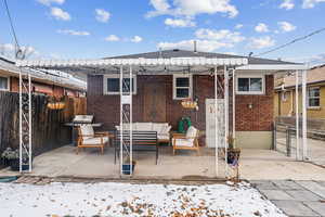 Snow covered rear of property featuring a patio area and an outdoor living space