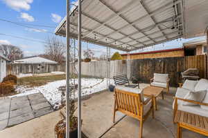 Snow covered patio featuring outdoor lounge area