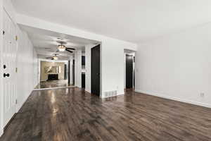 Empty room with ceiling fan and dark wood-type flooring