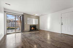 Unfurnished living room featuring dark wood-type flooring