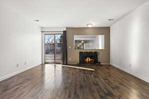 Unfurnished living room featuring ceiling fan and dark hardwood / wood-style floors