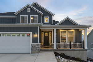 View of front of home with a porch and a garage