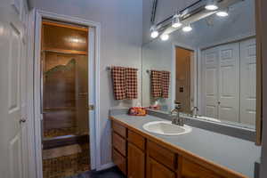 Primary bathroom featuring a steam shower with sliding door and vanity