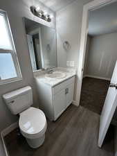 Bathroom with a textured ceiling, toilet, vanity, and wood-type flooring