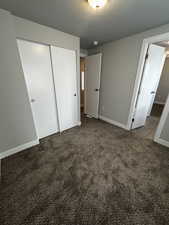 Unfurnished bedroom with a textured ceiling, a closet, and carpet flooring