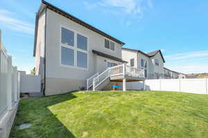 Rear view of property with a yard and a wooden deck