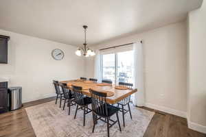 Dining room with dark hardwood / wood-style flooring and a chandelier