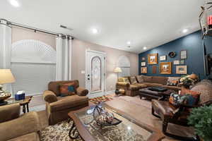 Living room with tile patterned flooring and vaulted ceiling