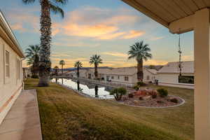 Yard at dusk featuring a water view