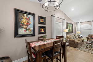 Dining space featuring an inviting chandelier and lofted ceiling