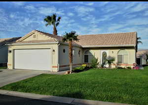 View of front of property with a garage and a front lawn