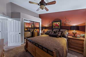 Bedroom with ceiling fan, vaulted ceiling, carpet floors, and a closet