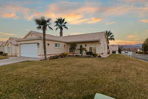 View of front facade with a yard and a garage