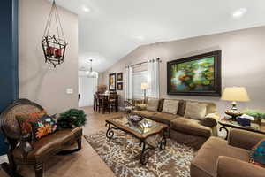 Tiled living room with a chandelier and vaulted ceiling