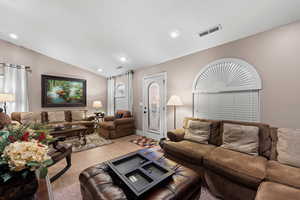 Living room with light tile patterned flooring and lofted ceiling