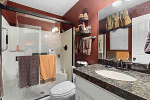 Bathroom with toilet, vanity, and walk in shower