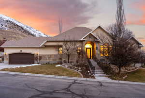 View of front of home featuring a mountain view, a garage, and a lawn