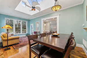 Dining area featuring unique ceiling fan and a skylight in the garden room