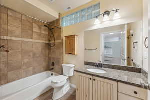 Full bathroom featuring tile floor, vanity, toilet, and tiled shower / bath