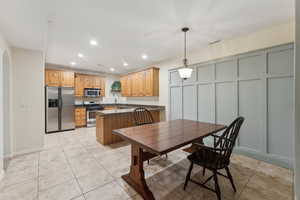 Basement kitchen and dining area with wainscoting, tile floor, granite countertops  and stainless steel appliances