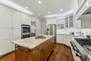 Kitchen with light granite countertops, prep sink, additional freezer drawer and stainless steel appliances